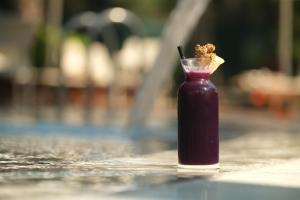 una botella de vidrio llena de líquido púrpura sentada en una mesa en Wome Prime Hotel - Halal All Inclusive, en Alanya