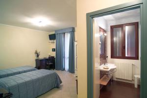 a bedroom with a bed and a bathroom with a sink at Hotel del Rio Srl - RISTORANTE e Azienda agricola in Casinalbo