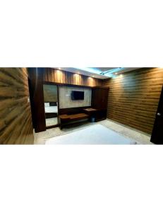 salon z telewizorem i ścianą w obiekcie Panchvati Inn, Bhedaghat w mieście Bherāghāt