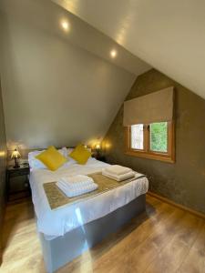 um quarto com uma cama com almofadas amarelas e uma janela em Lodge House in Grounds of Victorian Country Estate em Taunton