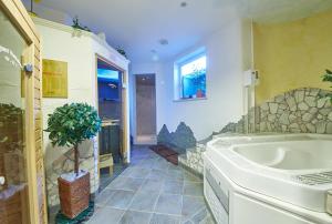 łazienka z wanną i doniczką w obiekcie Hotel Gamshag w Saalbach Hinterglemm