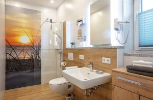 ein Badezimmer mit einem Waschbecken, einem WC und einem Spiegel in der Unterkunft Ferienwohnung Kiesenberg 9 in Thanstein