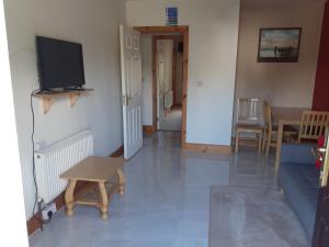 a living room with a tv and a couch and a table at AvonLodge in Waterford