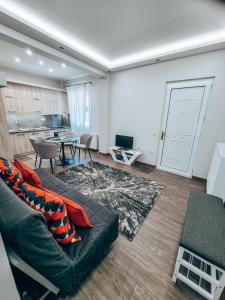 a living room with a couch and a table at Cozy Home in Klitoria