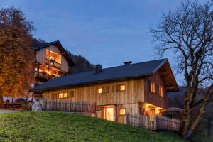 a house on a hill with a building in the background at Grossplonerhof in Luson