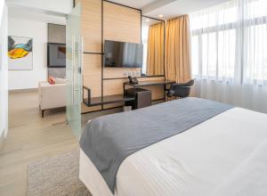 基苏木Sarova Imperial Hotel的配有床和书桌的酒店房间