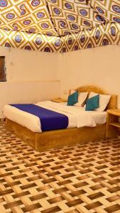 two beds in a room with a ceiling at Thar Royal Desert Camp in Sām