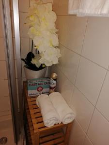 a towel rack with towels and a vase of flowers at Studio Steinbocks Chill in Kaprun