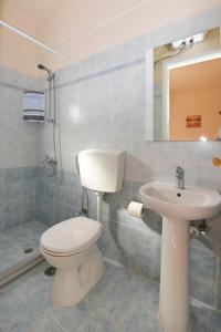 a bathroom with a toilet and a sink at CENTRAL APARTMENTs in Ermoupoli +25 photos