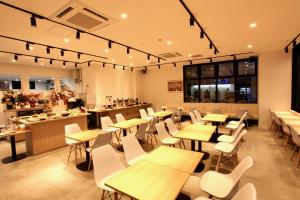 札幌的住宿－Sotetsu Fresa Inn Sapporo-Susukino，配有木桌和白色椅子的餐厅