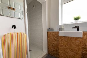 a bathroom with a sink and a white sink at Bethel Nook, a cosy stay in the Welsh Valleys in Hirwaun