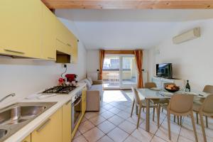 una cucina e un soggiorno con tavolo e sedie di Sunset Apartment Home & Terrace a Sirmione