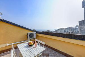 - un balcon avec une table et une corbeille de fruits dans l'établissement Sunset Apartment Home & Terrace, à Sirmione
