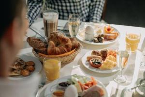uma mesa com pratos de alimentos e bebidas ao pequeno-almoço em Landhotel Bohrerhof em Feldkirch
