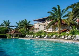 a resort with a pool and chairs and palm trees at Hotel Safari Gate in Bujumbura