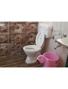 łazienka z toaletą, umywalką i wiadrem w obiekcie Panchvati Inn, Bhedaghat w mieście Bherāghāt