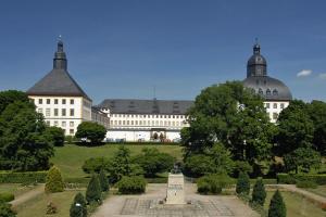 un gran edificio con un monumento en medio de un jardín en Ferienwohnung Beyer Friedrichroda, en Friedrichroda