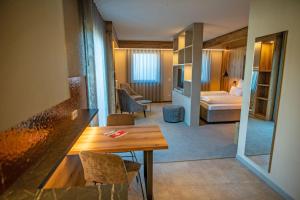 una habitación de hotel con una mesa y un dormitorio en GUESTHOUSE FELSENLAND, en Dahn