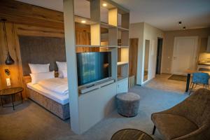 a hotel room with a bed and a flat screen tv at GUESTHOUSE FELSENLAND in Dahn