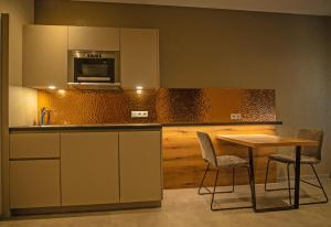 a kitchen with a table and chairs and a microwave at GUESTHOUSE FELSENLAND in Dahn