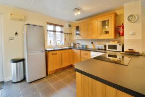 a kitchen with a refrigerator and a counter top at Nyhavn Lakeside Cottage in Cirencester