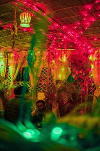 eine Gruppe von Menschen, die an einem Tisch mit Lichtern sitzen in der Unterkunft Pachamama Hostel in Jaipur