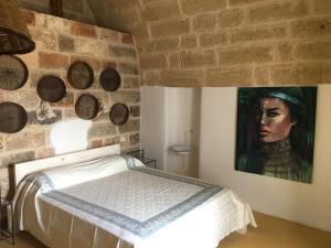1 dormitorio con 1 cama y una pintura en la pared en Tenuta Palmira agriturismo, en Salve