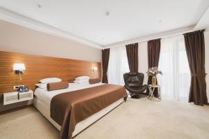 Pokój hotelowy z łóżkiem i krzesłem w obiekcie Hotel Aurel w mieście Podgorica