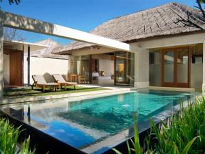 a swimming pool in front of a villa at The Bale Nusa Dua by LifestyleRetreats in Nusa Dua