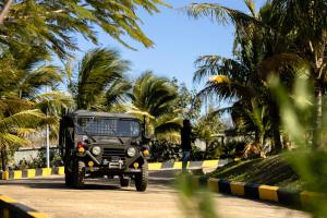 una jeep nera che percorre una strada con palme di KNN RESORT Mondulkiri a Sen Monourom