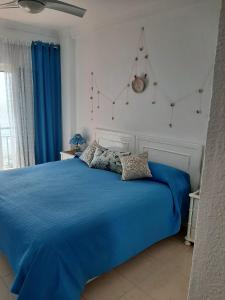 Schlafzimmer mit blauem Bett und blauer Bettwäsche in der Unterkunft Holiday wanda in Fuengirola