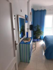 1 dormitorio con 1 cama y vestidor con espejo en Holiday wanda, en Fuengirola