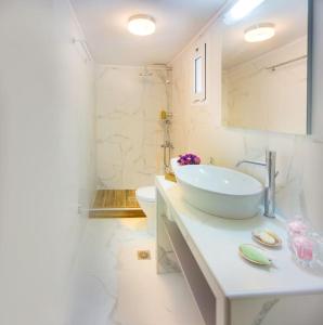 a white bathroom with a sink and a toilet at CRETAN VILLA OLIVIA in Karteros