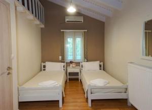 a room with two beds and a window at CRETAN VILLA OLIVIA in Karteros