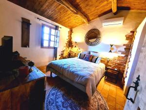 1 dormitorio con 1 cama en una habitación con techo de madera en CASEDDU A LECCIA vue mer et piscine, en Viggianello