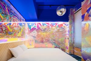 a bedroom with a painting on the wall at BnA WALL in Tokyo