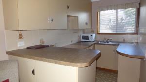 a kitchen with white cabinets and a counter top at Goomeri Motel in Goomeri