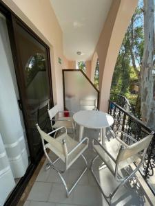 a white table and chairs on a balcony at Tersanas Beach Apartments in Chorafakia