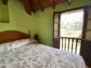 - une chambre avec un lit et une grande fenêtre dans l'établissement Casa El Marizal 1 Arriondas, à Arriondas