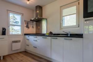 a kitchen with white cabinets and a sink at Chalet Lara in Fiesch