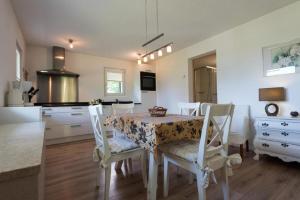 a kitchen with a table and chairs and a kitchen with a stove at Chalet Lara in Fiesch