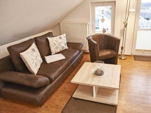 a living room with a leather couch and a coffee table at Wohnpark Stadt Hamburg in Binz - WG 57 in Binz