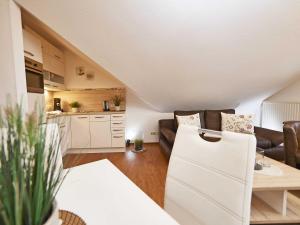 uma pequena sala de estar com um sofá e uma cozinha em Wohnpark Stadt Hamburg in Binz - WG 57 em Binz