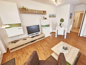 ein Wohnzimmer mit einem TV und einem Tisch in der Unterkunft Wohnpark Stadt Hamburg in Binz - WG 57 in Binz