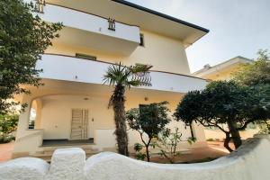 een huis met een palmboom ervoor bij Appartamento Vespucci Bilo - MyHo Casa in Tortoreto Lido