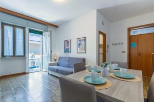 een woonkamer met een tafel en een blauwe bank bij Appartamento Vespucci Bilo - MyHo Casa in Tortoreto Lido