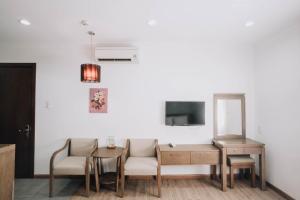 salon z kanapą, stołem i telewizorem w obiekcie Song Hưng Hotel & Serviced Apartments - Căn hộ Dịch vụ & Khách sạn w Ho Chi Minh