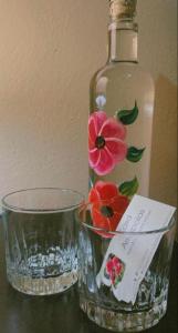 una bottiglia d'acqua e una ciotola di vetro con un fiore dipinto sopra di Casa Amapolas Oaxaca a Città di Oaxaca