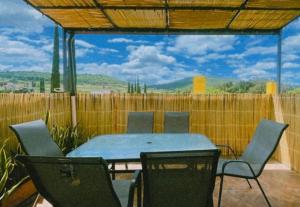 patio con tavolo, sedie e recinzione di Casa Amapolas Oaxaca a Città di Oaxaca