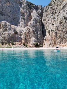 una playa con agua azul y una montaña rocosa en Sailing Yacht Armida Rhodes, en Rodas